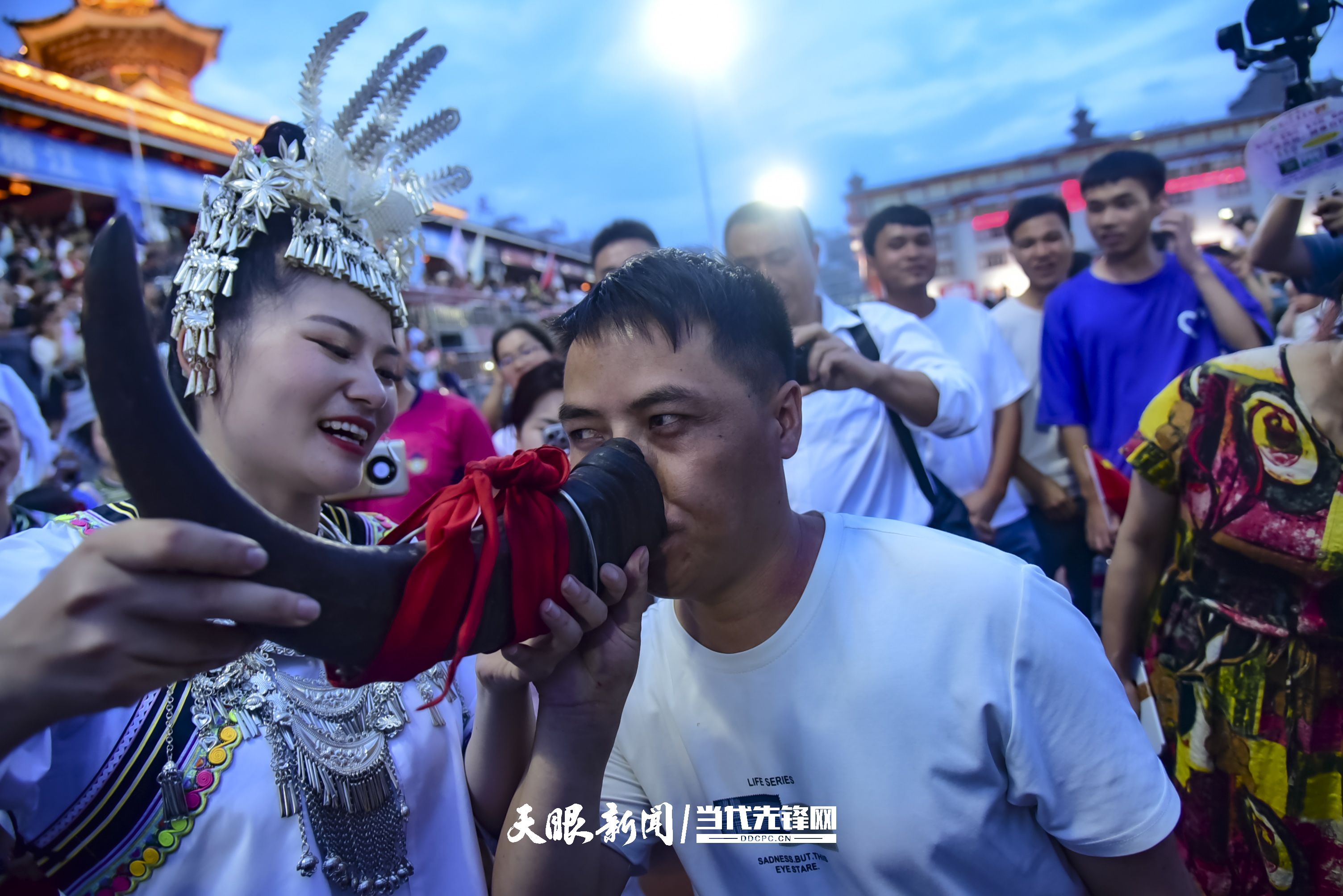 村超現(xiàn)場(chǎng)，當(dāng)?shù)厝罕娤蜻h(yuǎn)道而來(lái)的游客敬酒。 潘邵平 攝.jpg