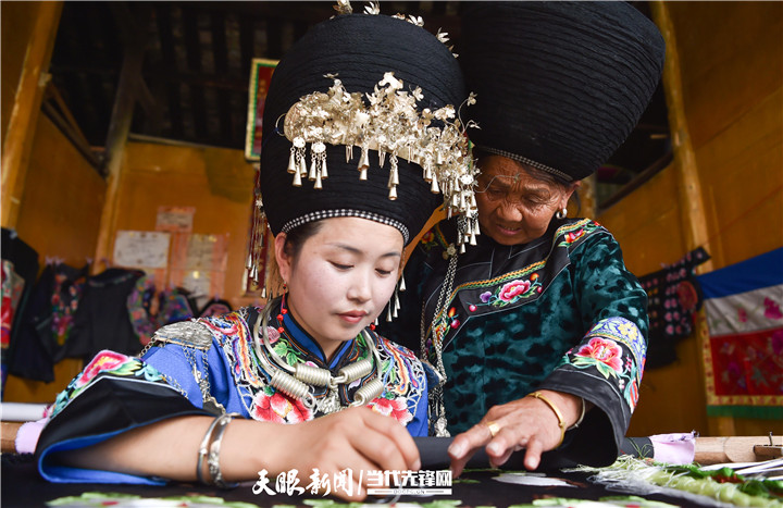 在貴州省銅仁市松桃苗族自治縣太平營(yíng)街道老寨村，一老人在指導(dǎo)繡娘繡苗繡。.jpg